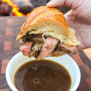 A photo of the sandwich being dipped in the au jus.