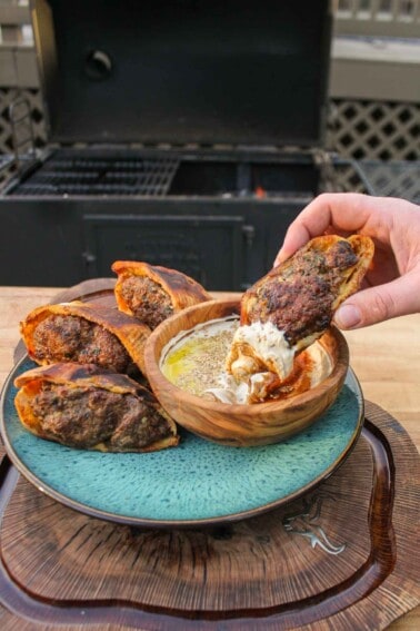 The Grilled Lamb Arayes being dipped into the tahini sauce.