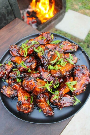 A plate full of Hot Honey Garlic Wings that are garnished and served.