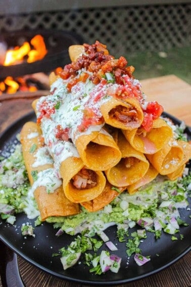 The taquitos sitting on the serving plate.