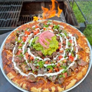 Carne Asada Pizza assembled and ready for slicing.