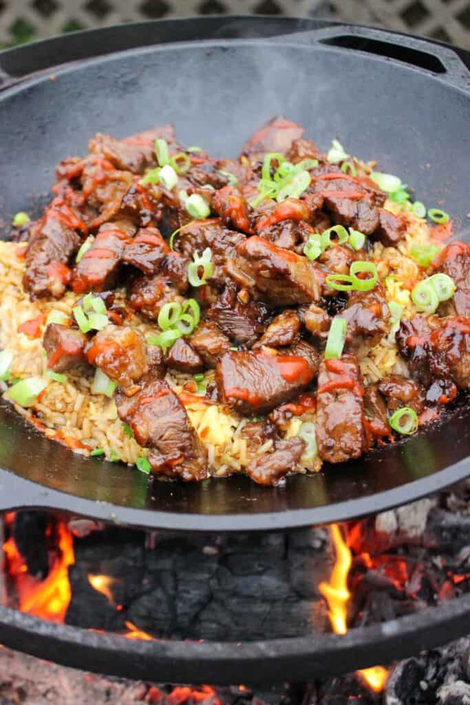 Garlic Teriyaki Steak Bites over a bed of fried rice ready to serve.