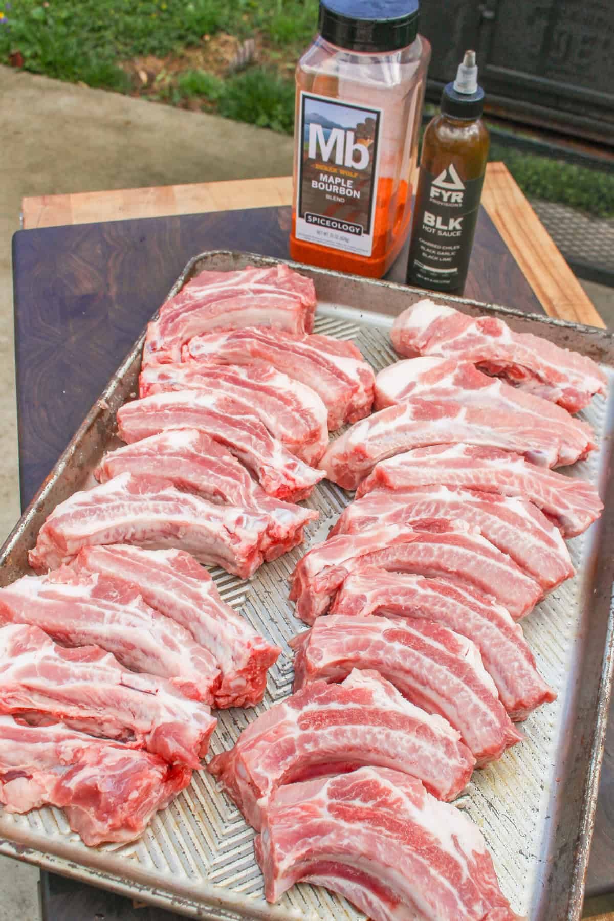 Maple Bourbon BBQ Rub sitting with raw ribs about to be seasoned.
