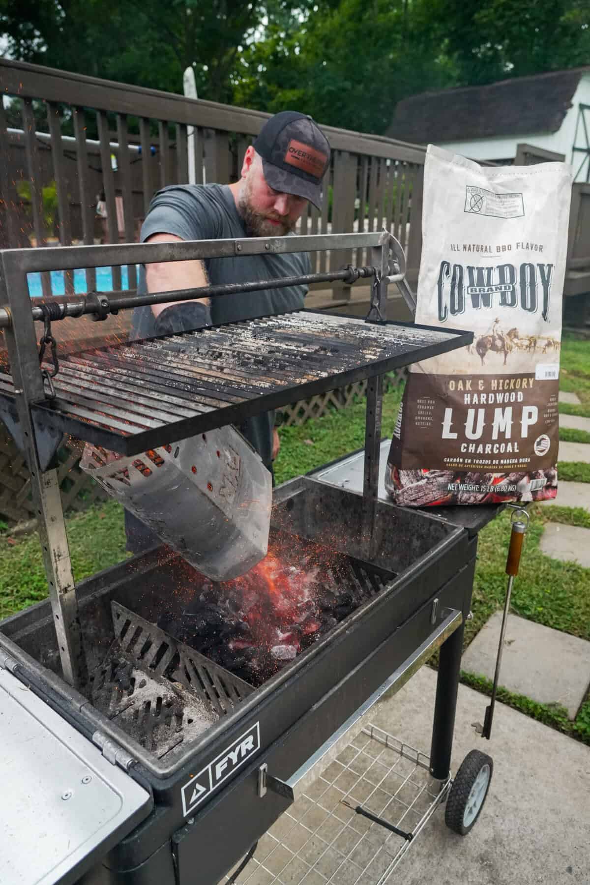 Derek Wolf adding Cowboy Charcoal out of a chimney starter to a FYR Grill