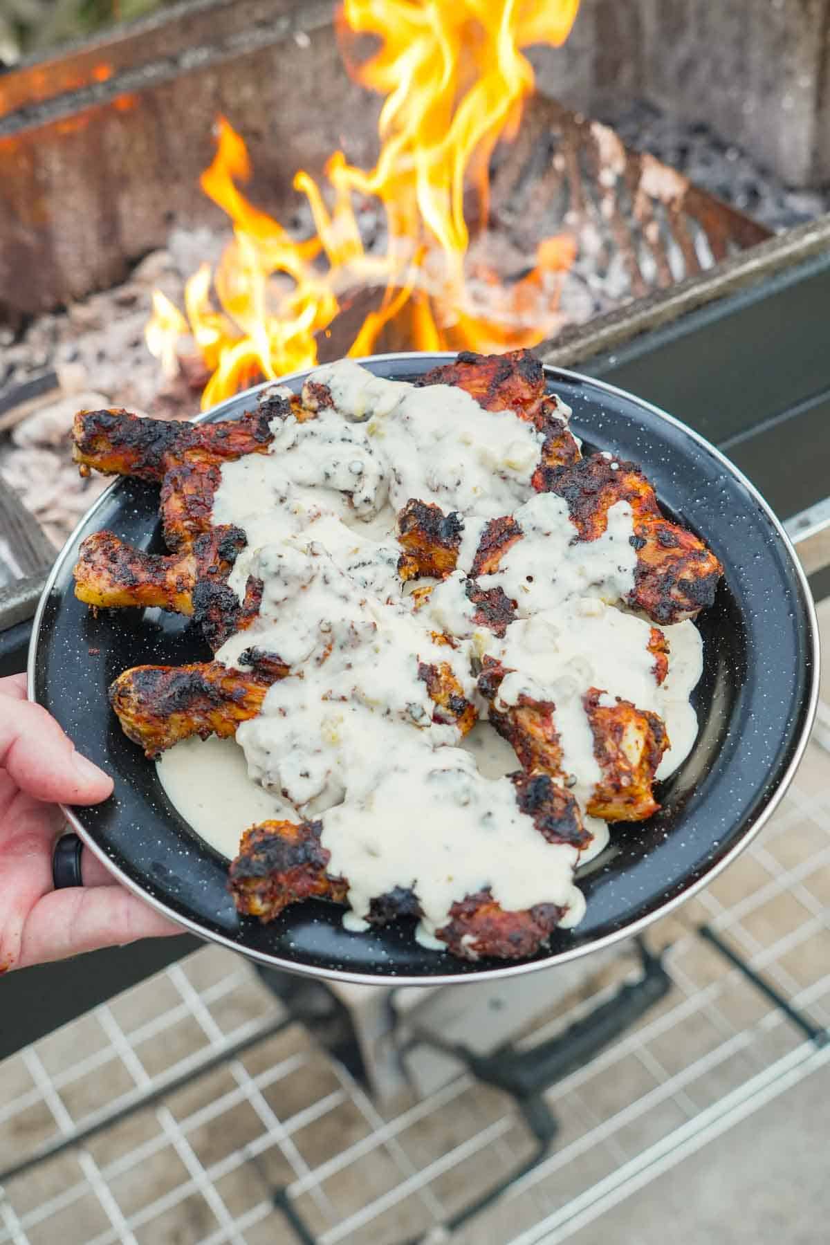 The plate of Butterflied drumsticks is ready and smothered in our homemade queso.