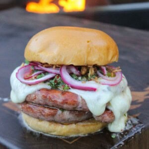 The Choripan Burger is a work of art that combines all the best flavors of sausage, cheese, and pickled onions.