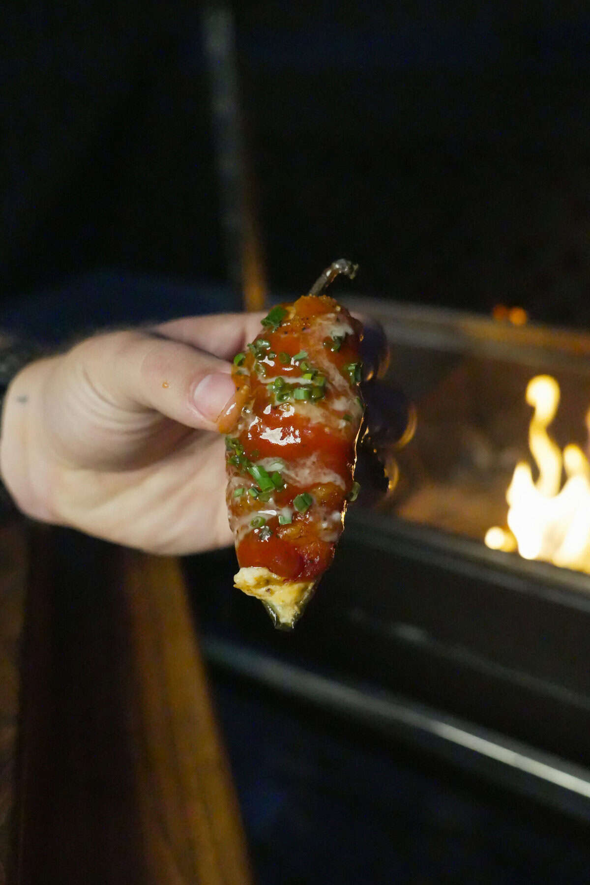 A close up of a Jalapeno Popper glazed with BBQ sauce.