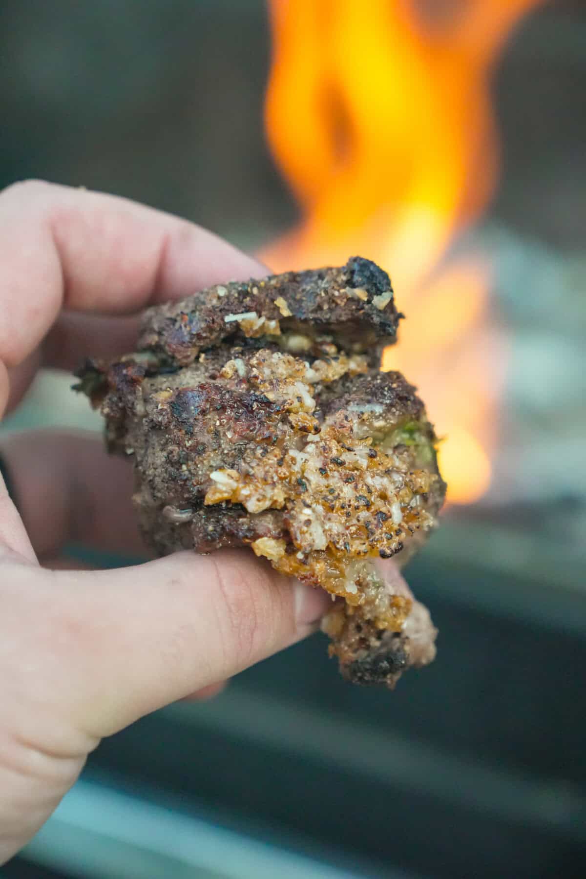 A close up shot of the steak skewers with Derek Wolf holding the bite in his hands.
