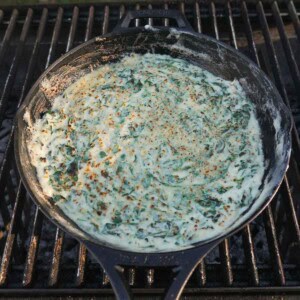 Cream spinach in a cast iron skillet on the grill