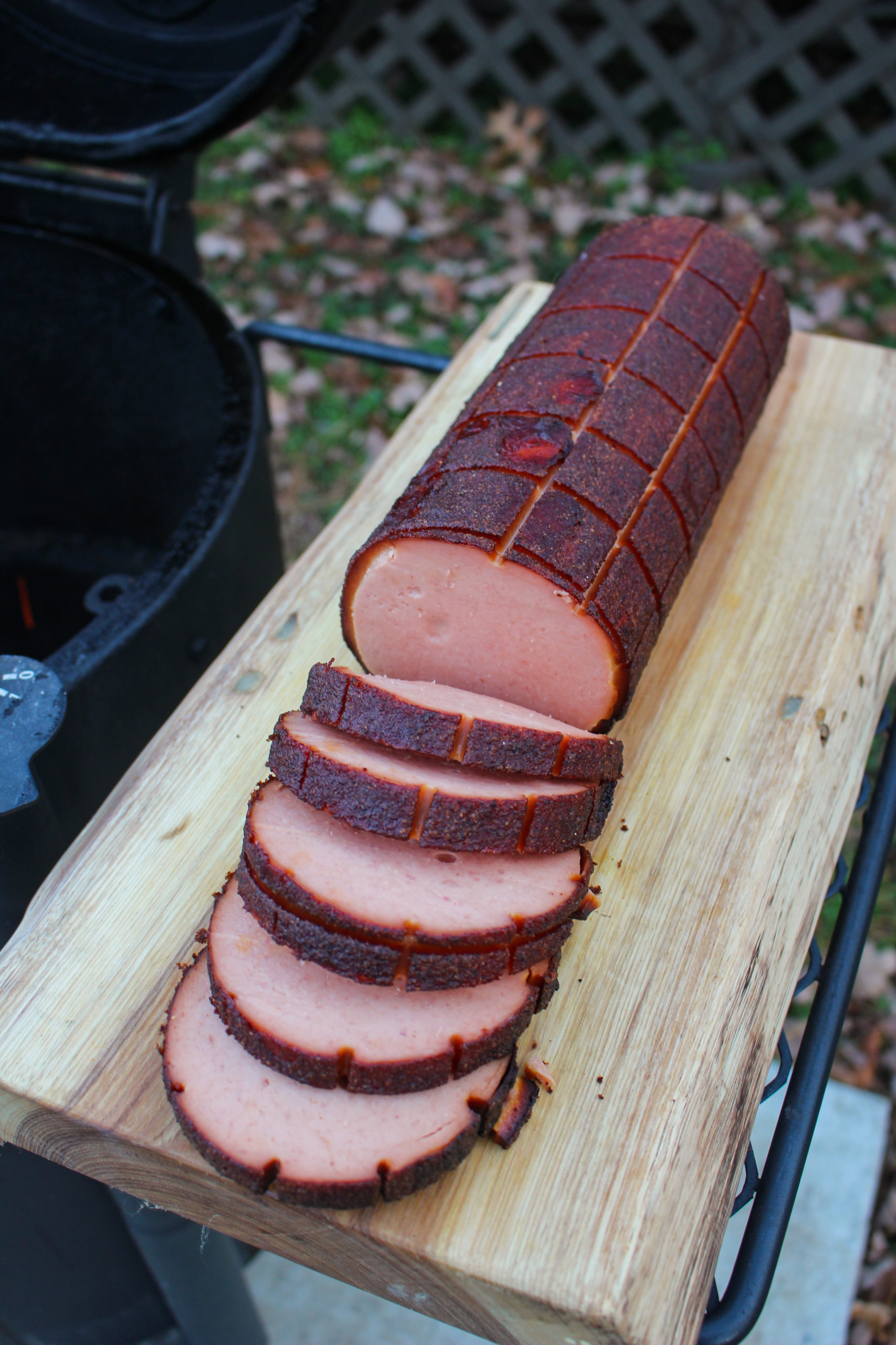 Smoked Bologna sliced on a cutting board.