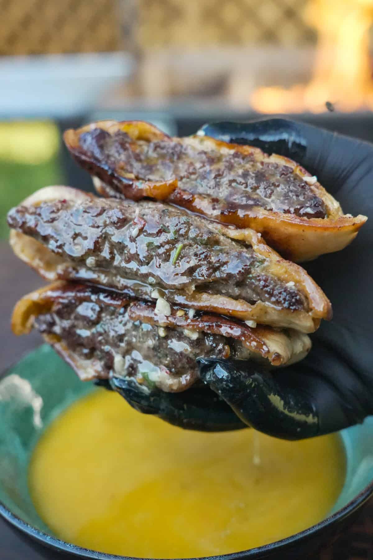 A close-up of the Cowboy Butter Arayes in the hands of Derek Wolf, juicy and tasty looking.