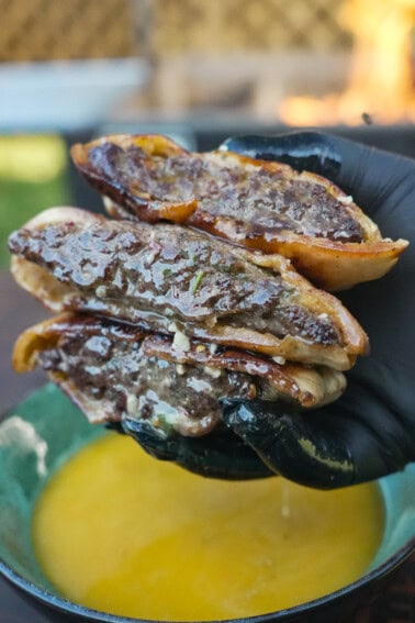 A close-up of the Cowboy Butter Arayes in the hands of Derek Wolf, juicy and tasty looking.