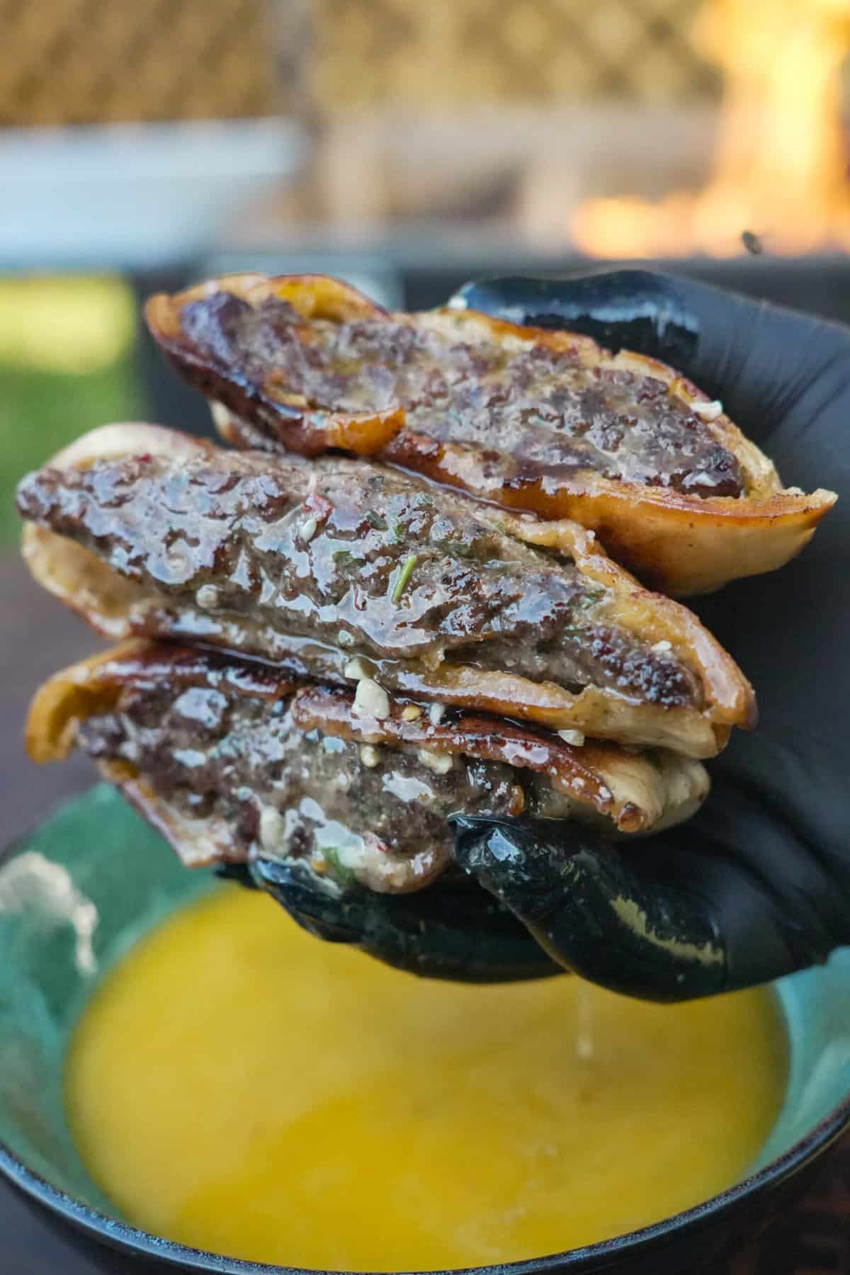 A close-up of the Cowboy Butter Arayes in the hands of Derek Wolf, juicy and tasty looking.