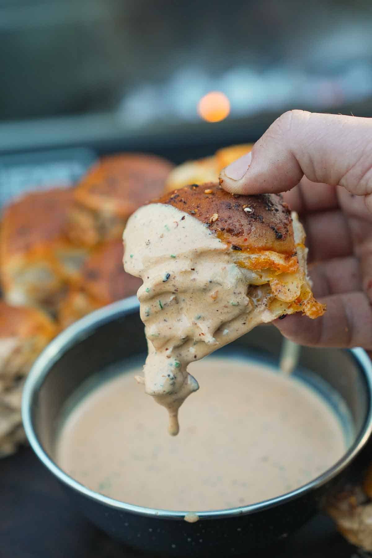 A hot honey chicken slider is dipped in our spicy ranch dressing.