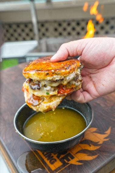 Dipping the pizza smashburger in garlic Parmesan butter