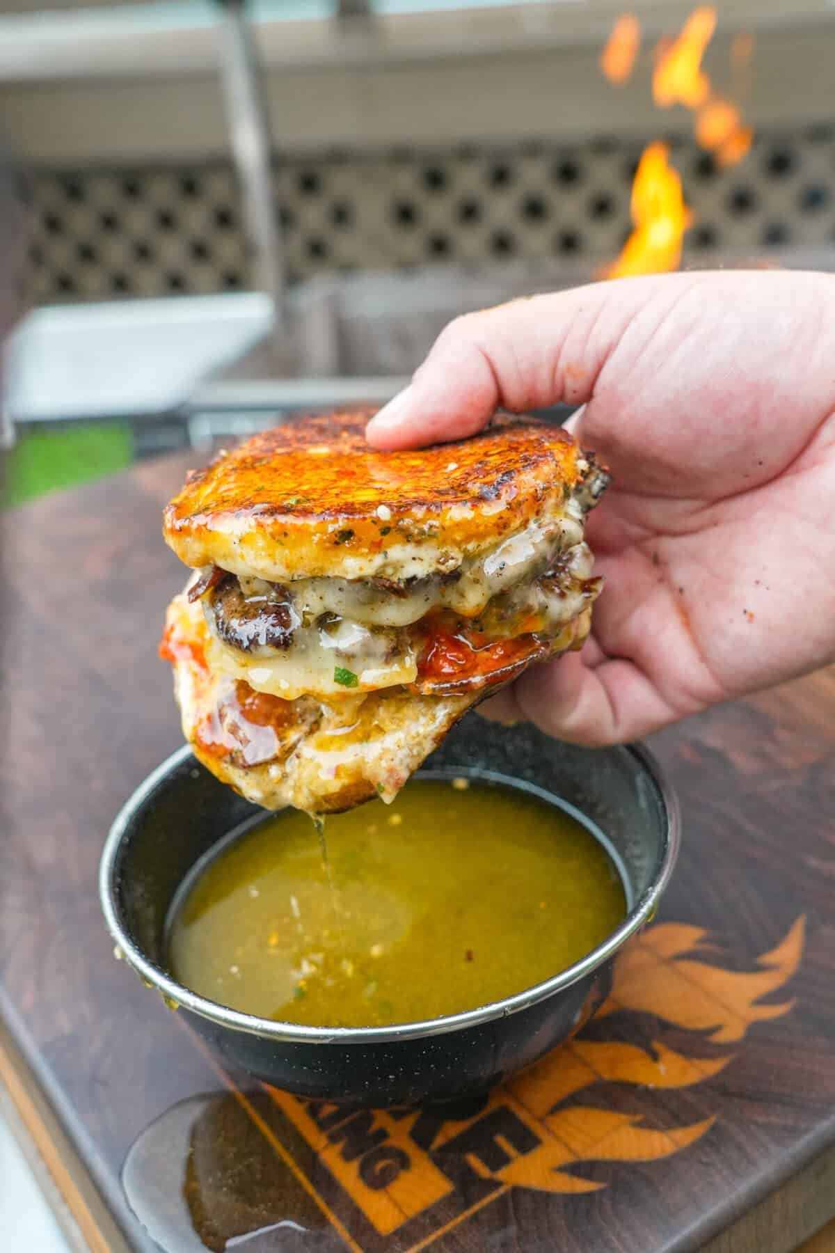 Dipping the pizza smashburger in garlic Parmesan butter