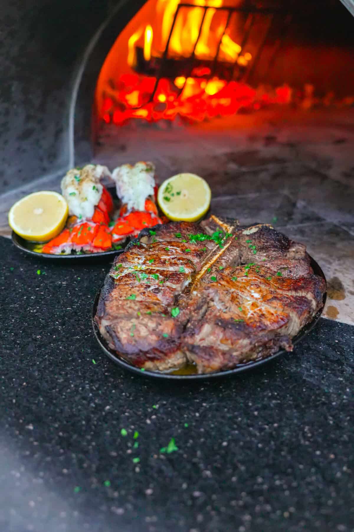 Seasoned T-bone steak after a searing in a hot skillet by the fire.