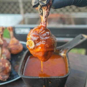 Dipping a chicken lollipop into the honey BBQ glaze
