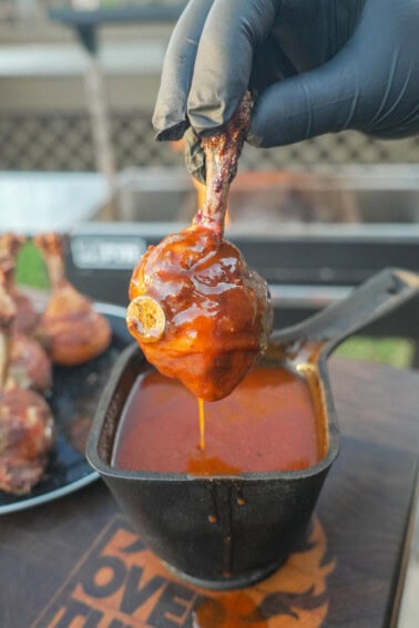 Dipping a chicken lollipop into the honey BBQ glaze
