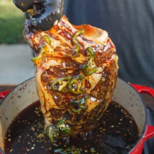 Close up of steak being pulled out of the honey and jalapeno cure.