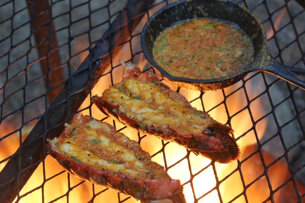 lobster and butter on the grill grate over the fire