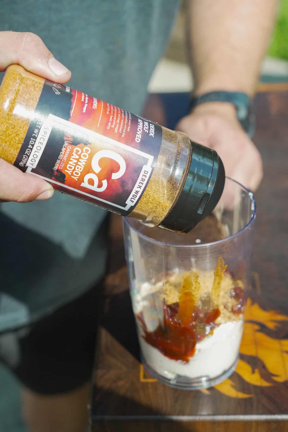 Adding Cowboy Candy to the sauce before mixing.