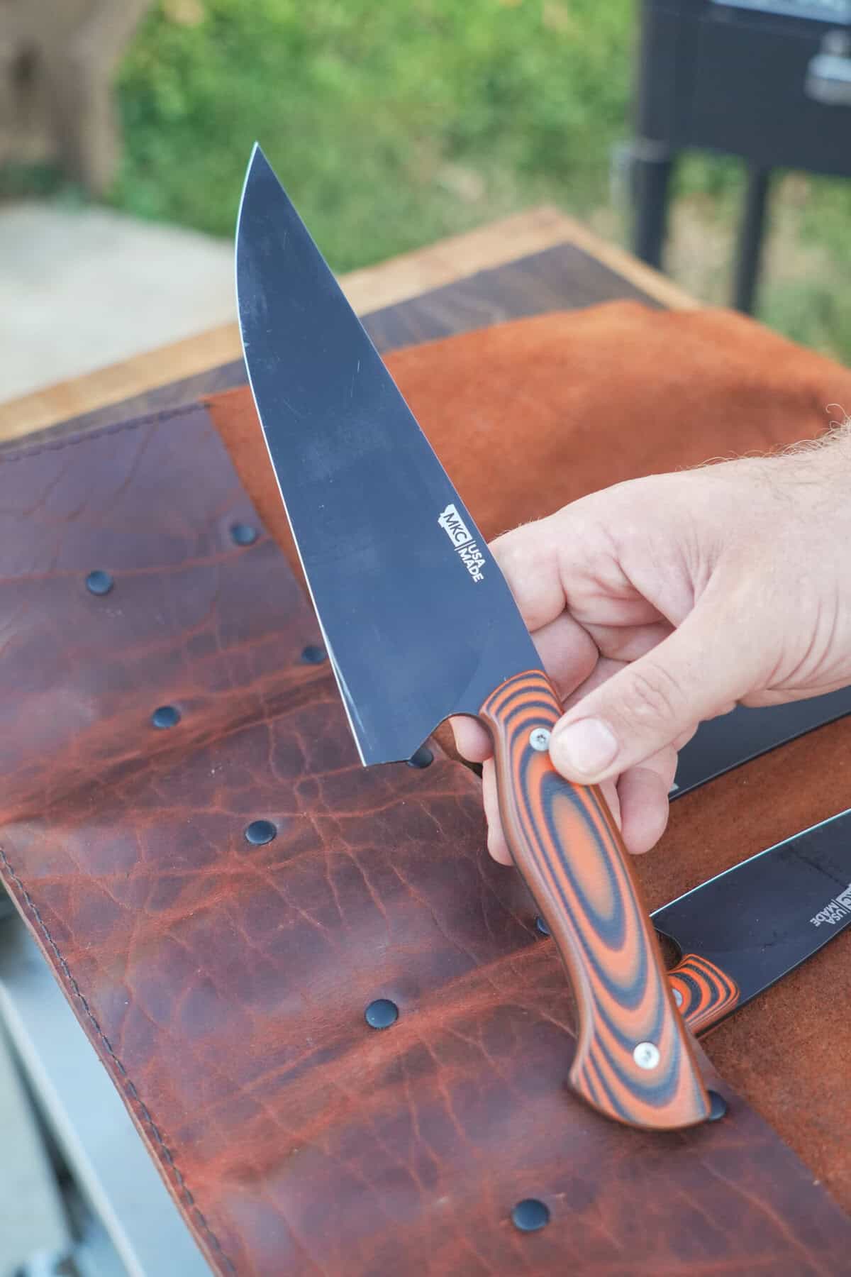 A close up of the Montana Knife, a cooking essential for the quality and sharpness you need for cutting steak on a cutting board.