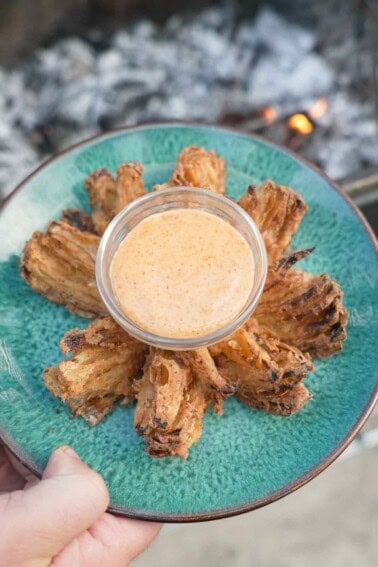 The Bloomin' Onion is served up on a pretty dish with the spicy dipping sauce in a serving bowl in the center.