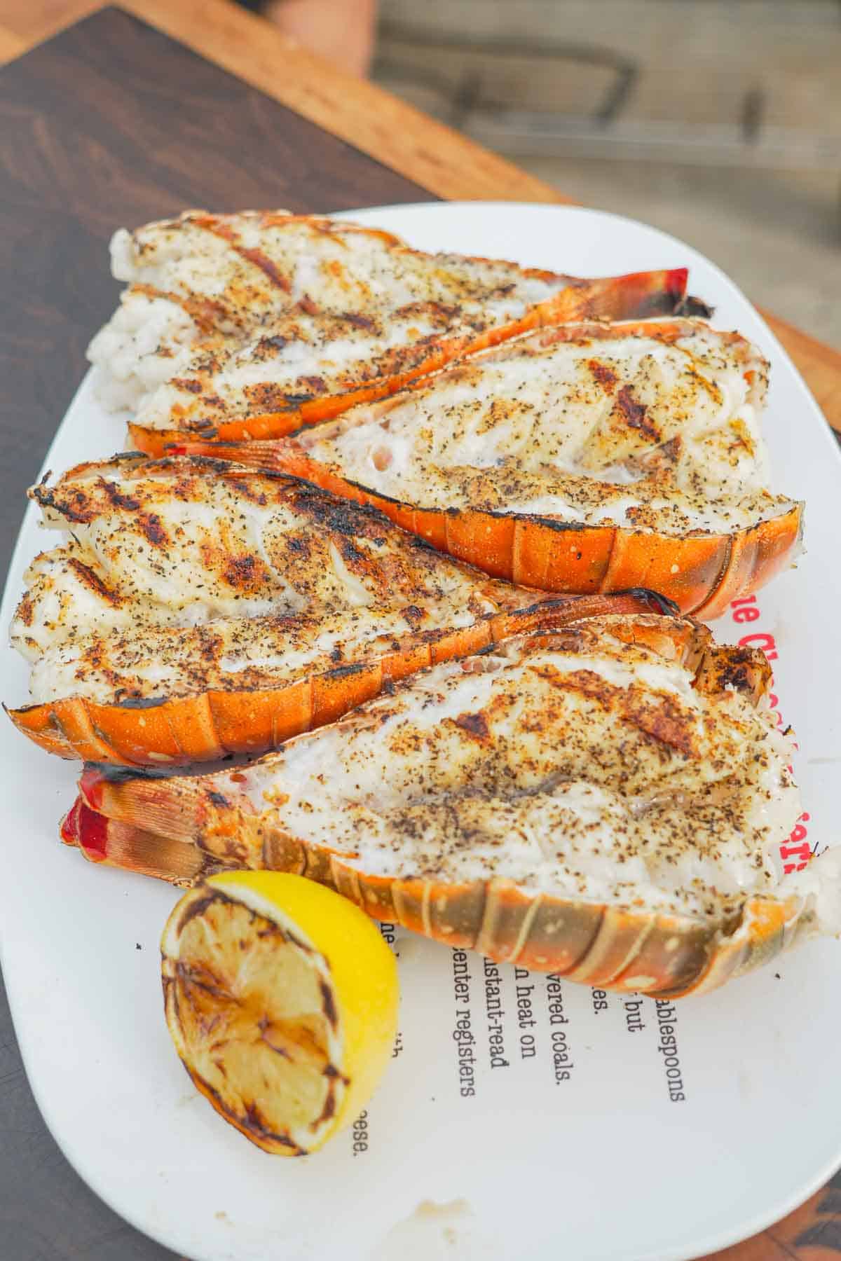 Grilled meat arranged on a plate with lemon on the side