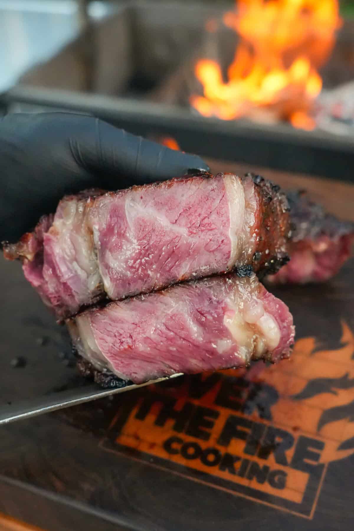 A super closeup of the medium rare steak after being cut with a sharp knife. View of the marbling and juices.