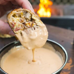 Dipping the steak breakfast burrito in Queso.