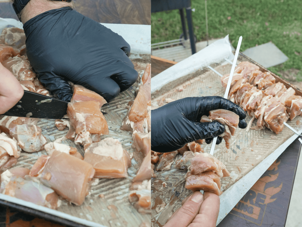 Using a sharp knife to slice the boneless skinless chicken thighs and bacon into 2x2 inch cubes and threading the meat onto metal skewers