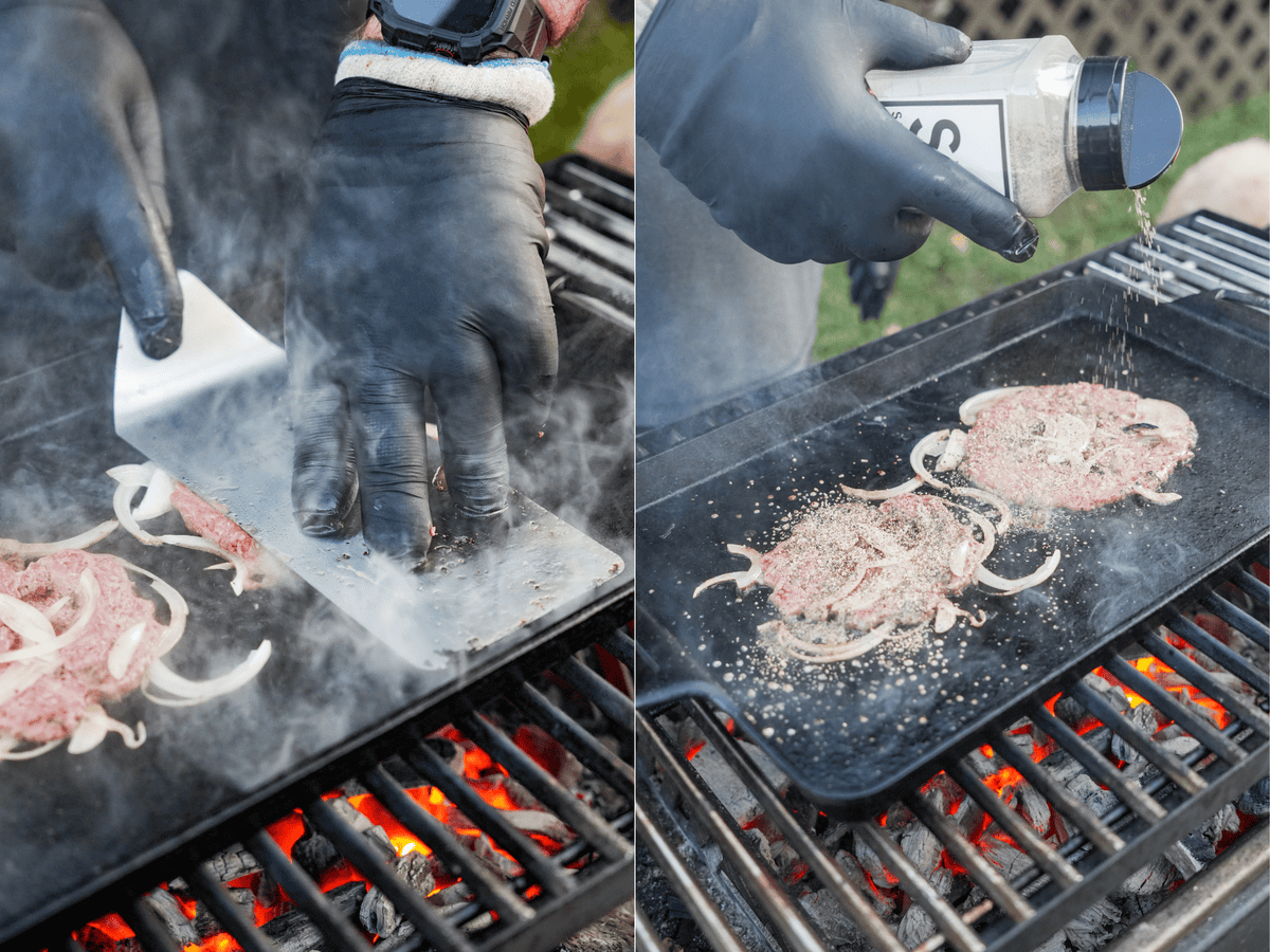 Smashing and seasoning the burgers on the cast iron grill, with onions.